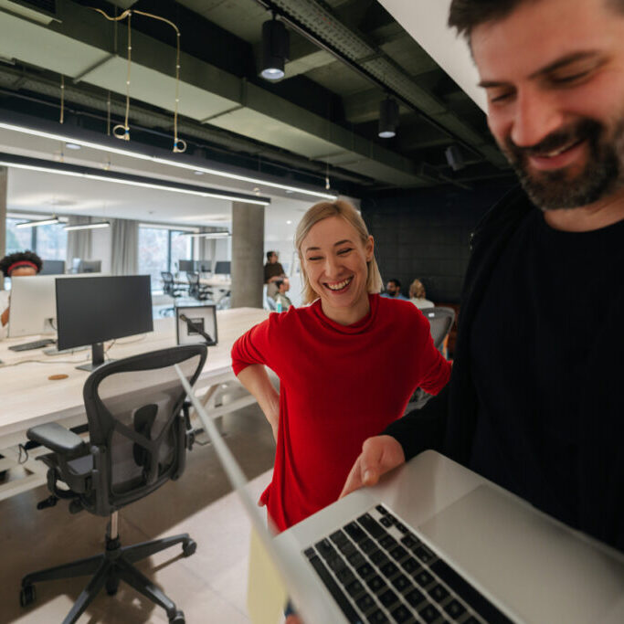 Photo of colleagues using a laptop in their office