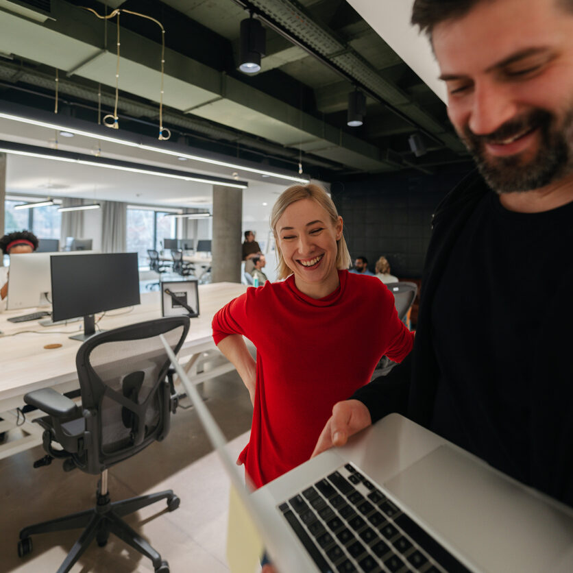 Photo of colleagues using a laptop in their office
